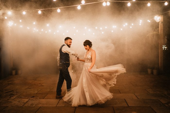 wedding day couple dancing with smoke and twinkle lights