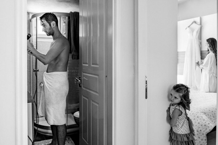 little girl watching parents get ready for wedding