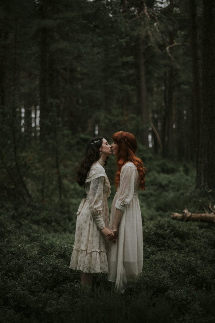 same-sex couple kiss in forest