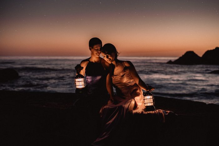 same sex couple on beach with lanterns April top pic