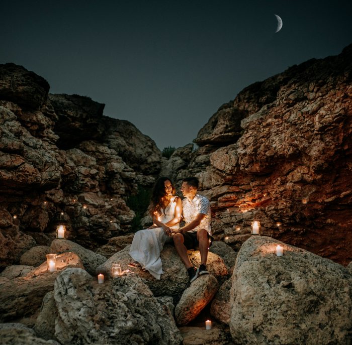couple in rocky terrain surrounded by candles