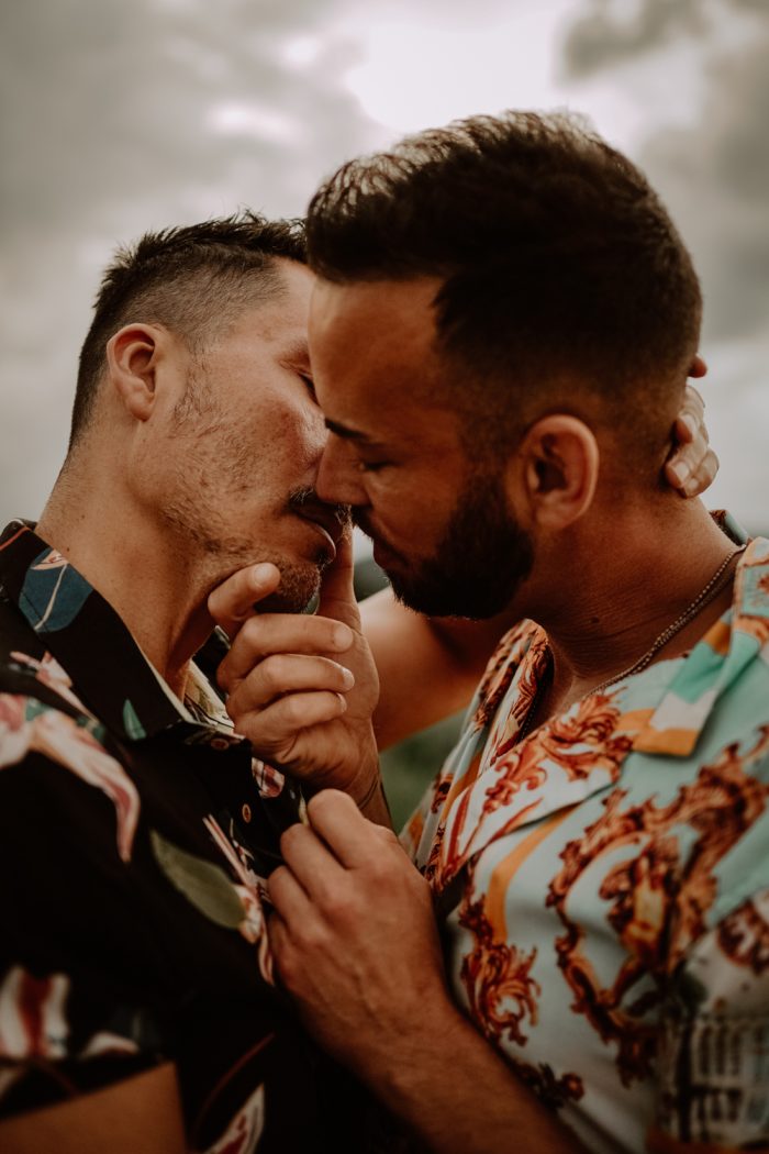 same-sex couple in floral shorts embracing