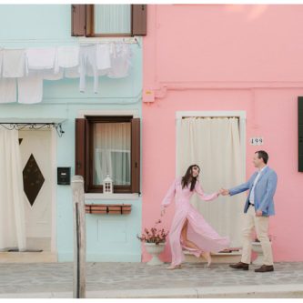 couple walking in front of colorful buildings