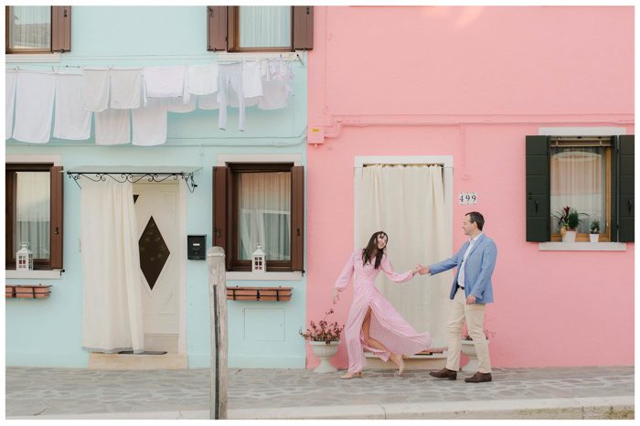 couple walking in front of colorful buildings