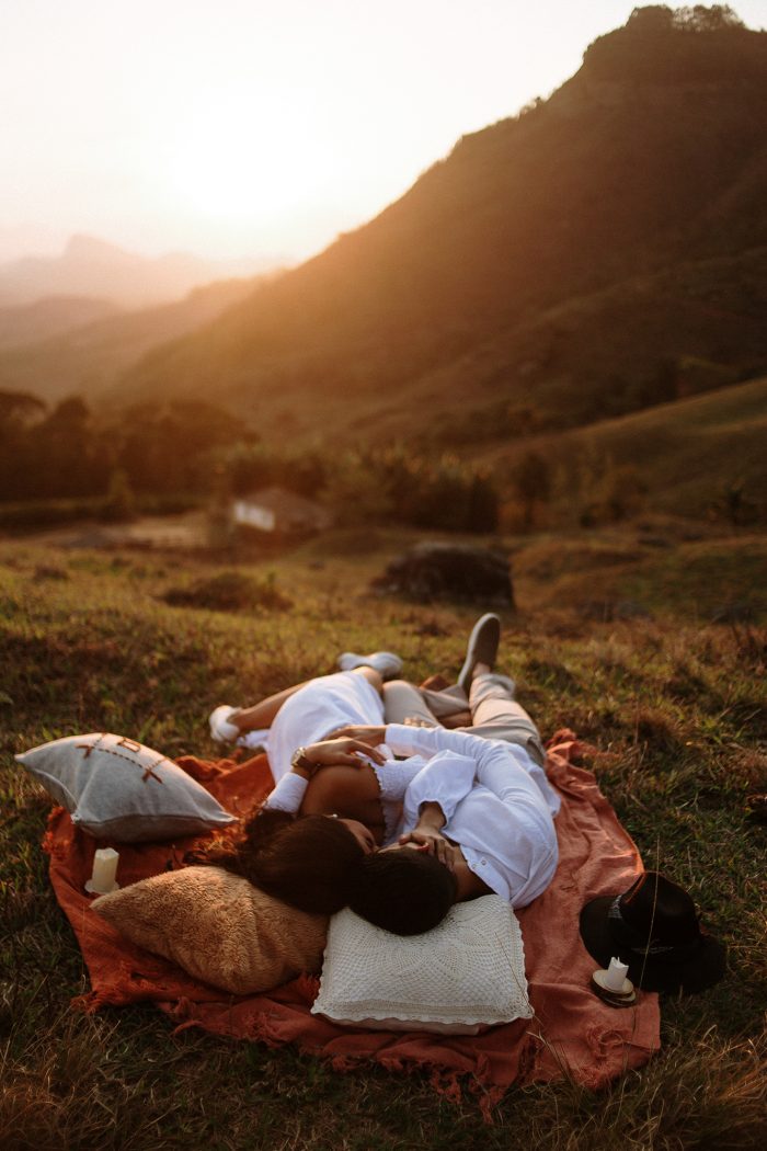 couple cuddling on picnic blanket at sunset
