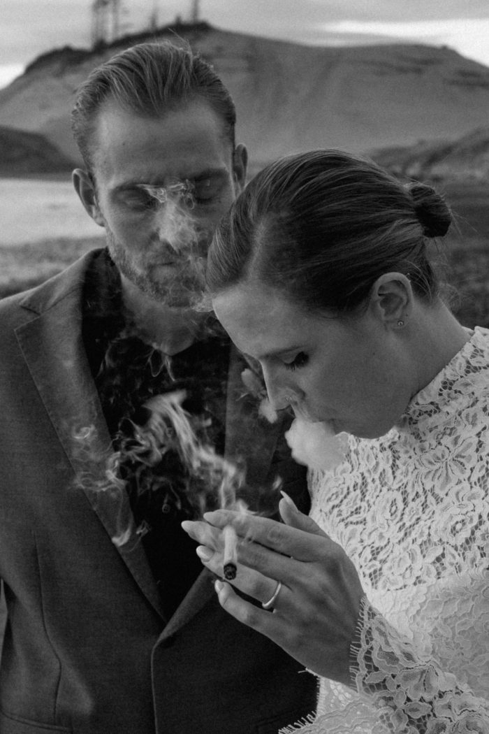 bride smoking joint on beach next to groom