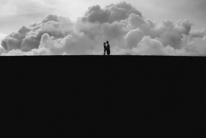 dramatic black and white landscape of couple on horizon