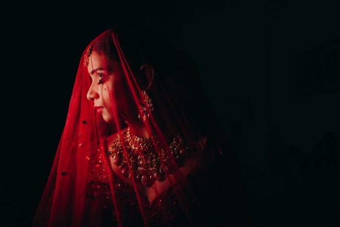traditional Indian bride with red veil and intricate jewelry