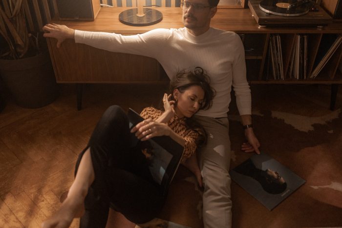 hipster couple lounging with records and record player