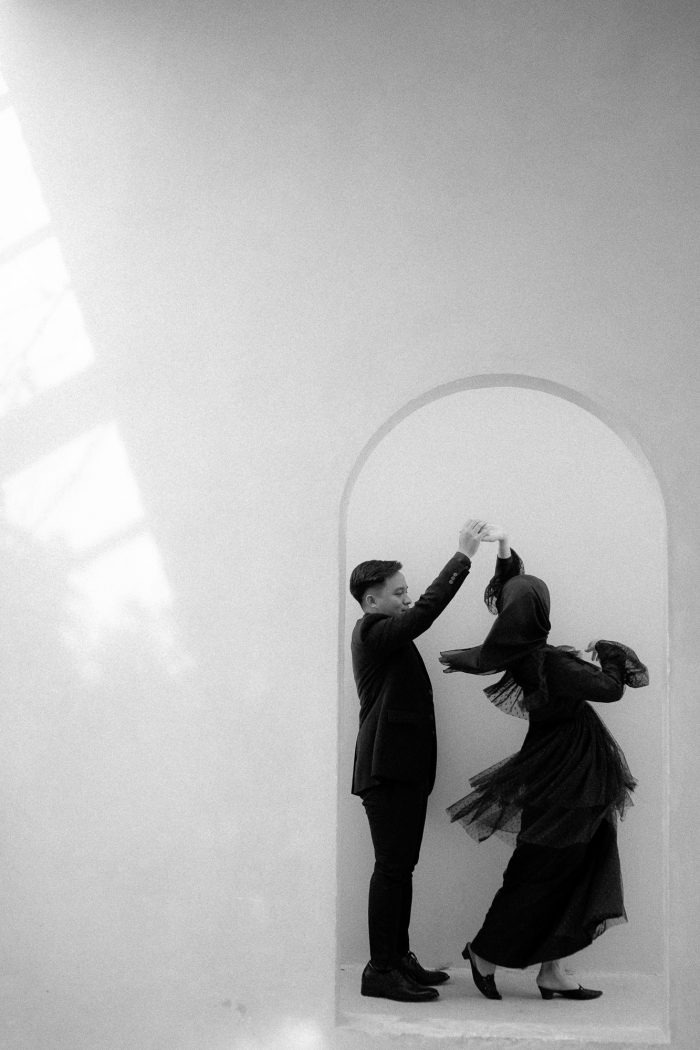 black and white photo couple dancing in door frame