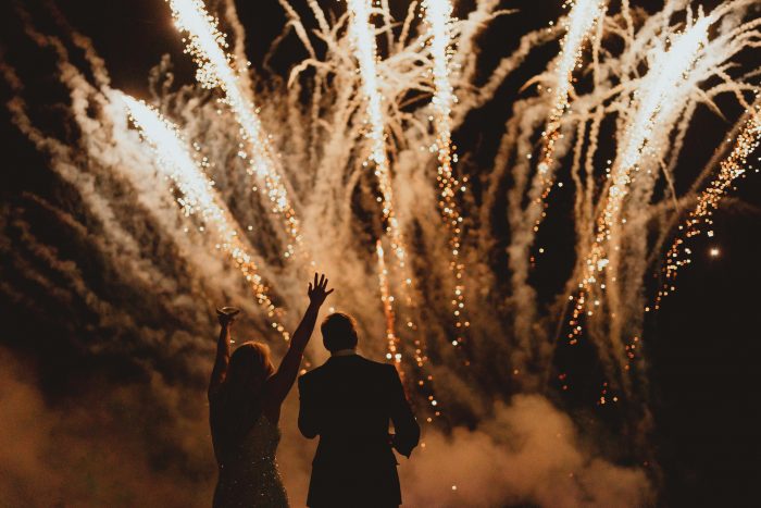 couple in front of fireworks on wedding day 