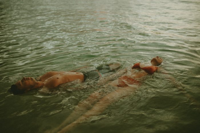 artistic photo of couple floating on water 