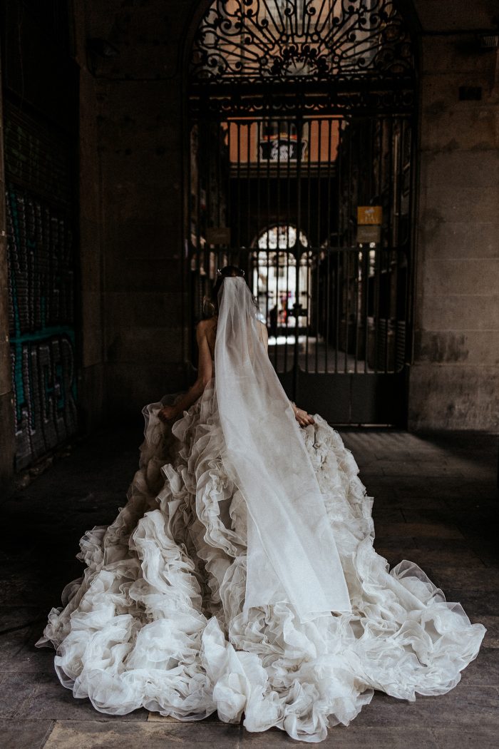 bride in intricate bridal gown with ruffles inside chapel