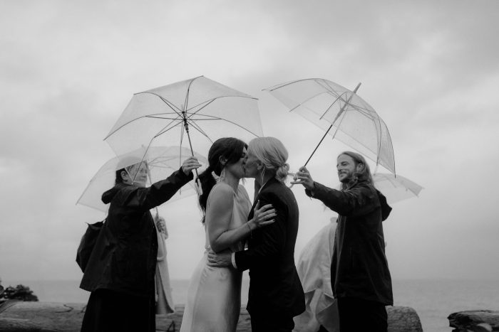 same-sex wedding day with umbrellas in the rain
