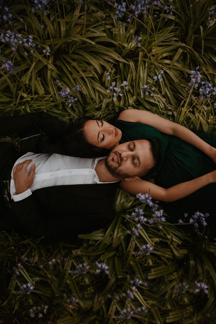 couples laying in a bed of flowers with eyes closed