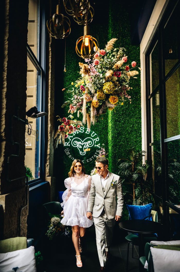 bright colorful hanging florals over wedding couple