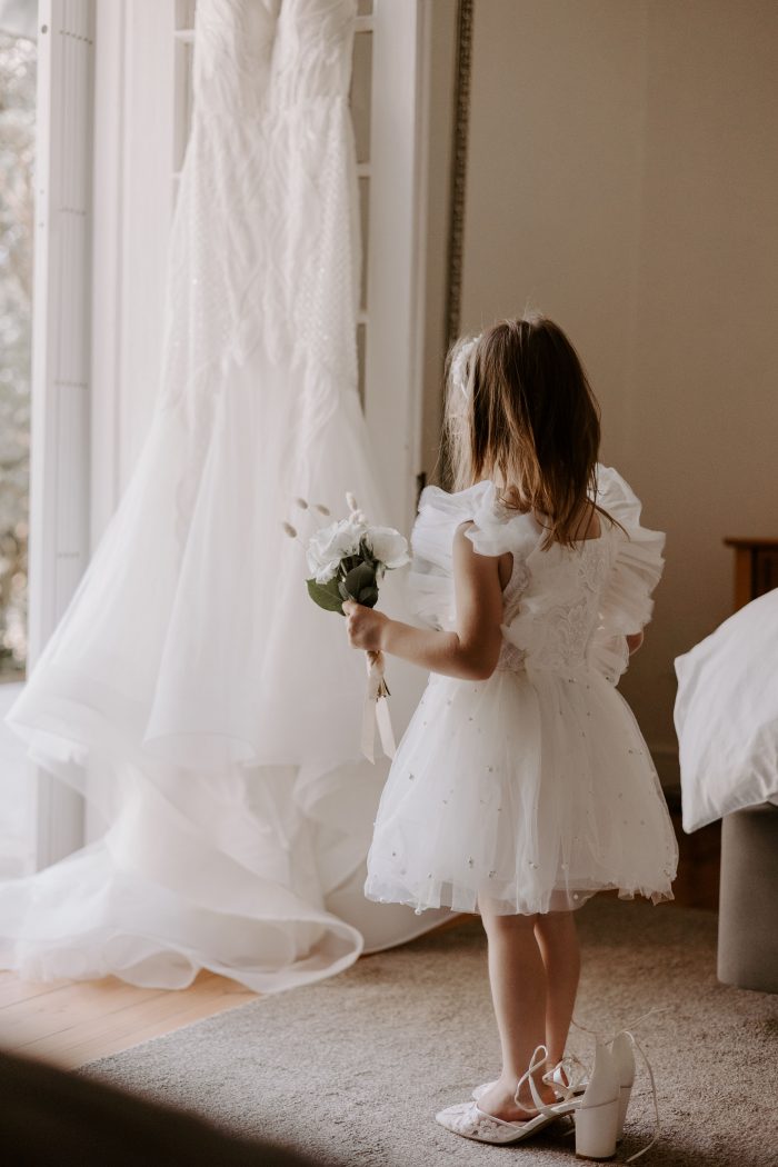 cute flower girl trying on brides shoes 