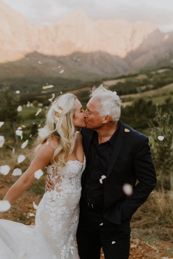 older couple kissing on wedding day with flower petals