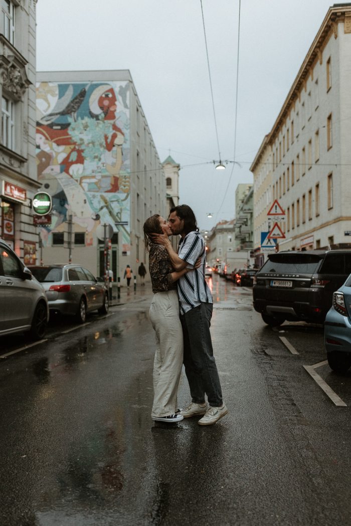 couple kissing in city street in the rain