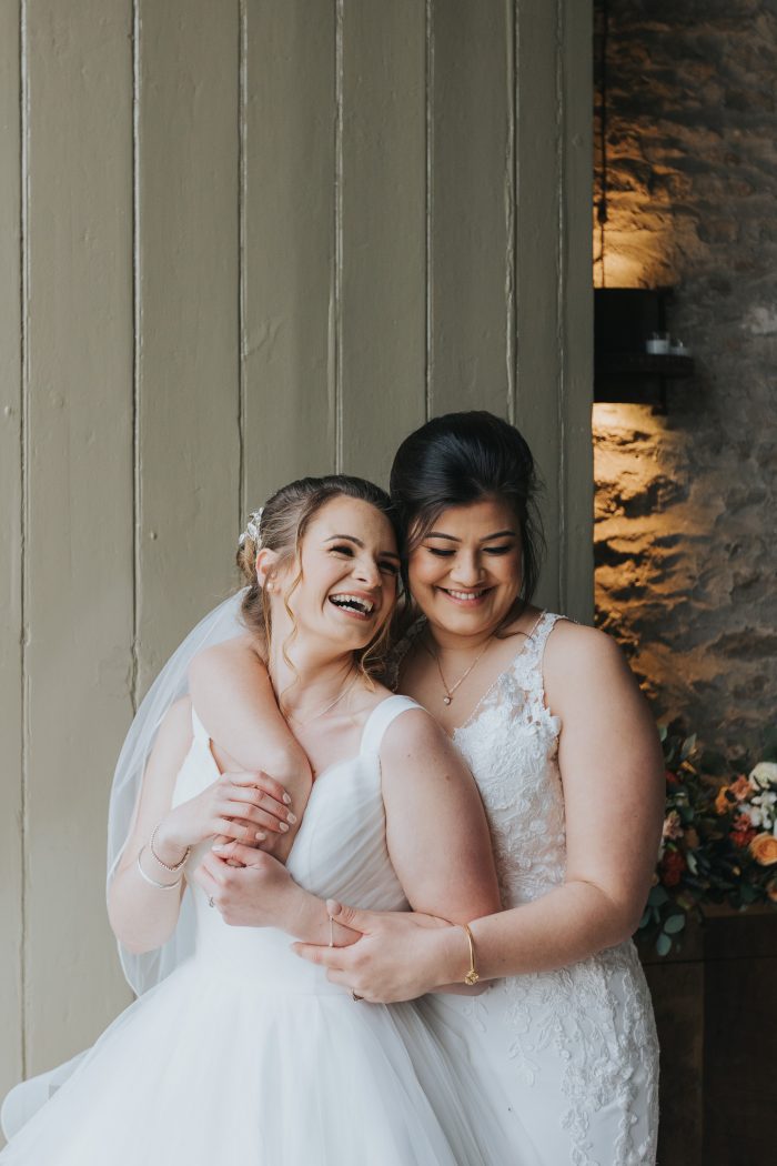 happy portrait of two brides embracing