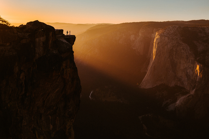 Couple on cliff in Yosemite at sunset