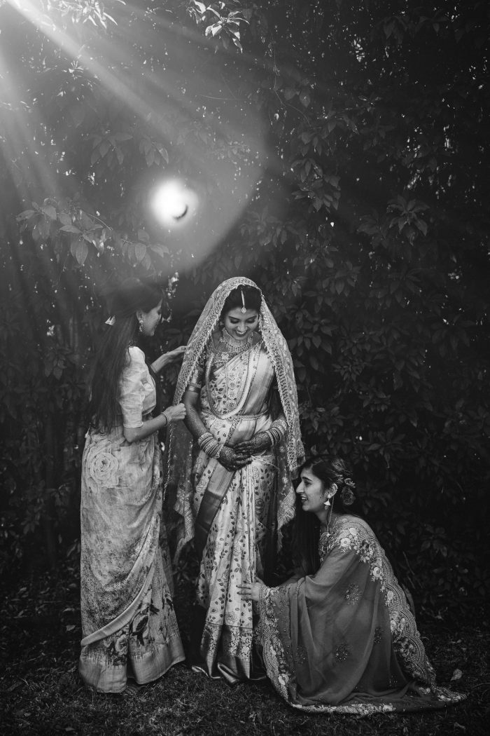black and white shot of Indian bride posing with bridesmaids