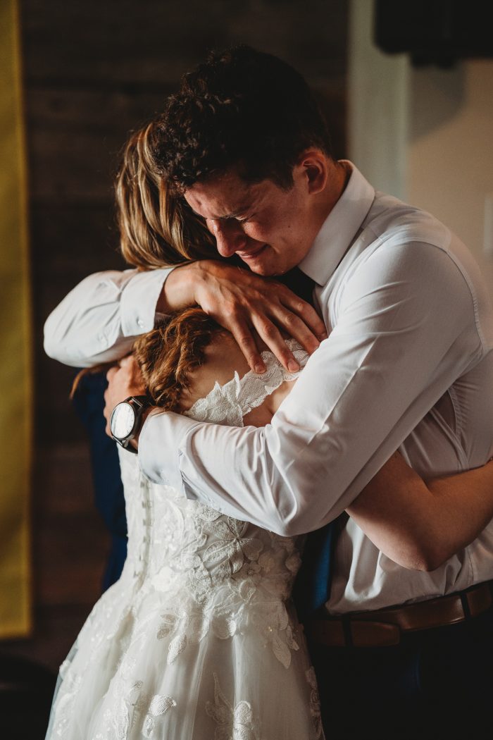 groom crying onto bride's shoulder after first look
