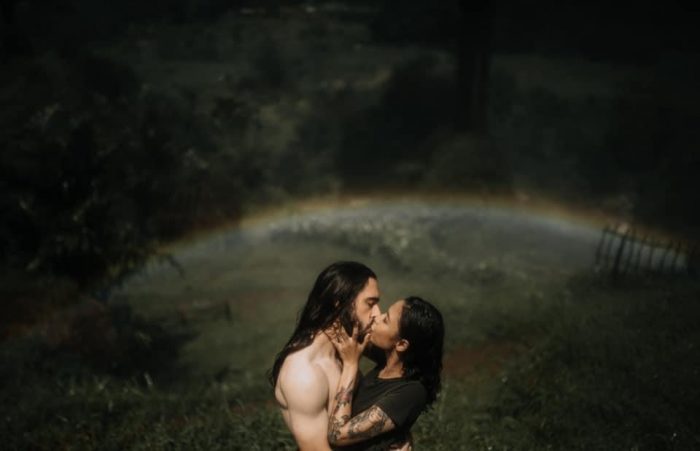 couple kissing under misty rainbow