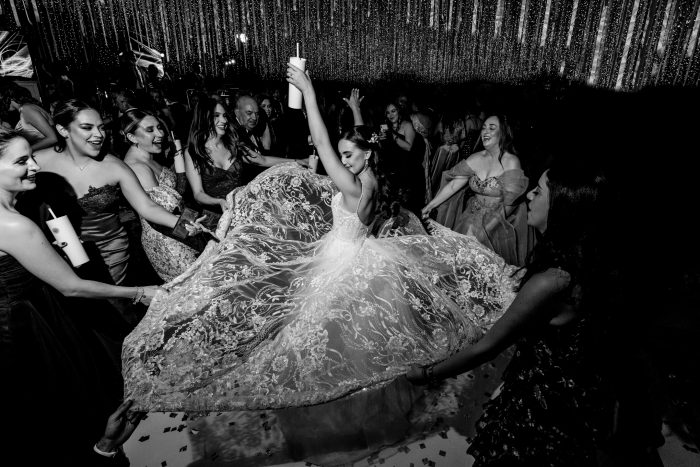 bride dancing in the middle of friends at reception