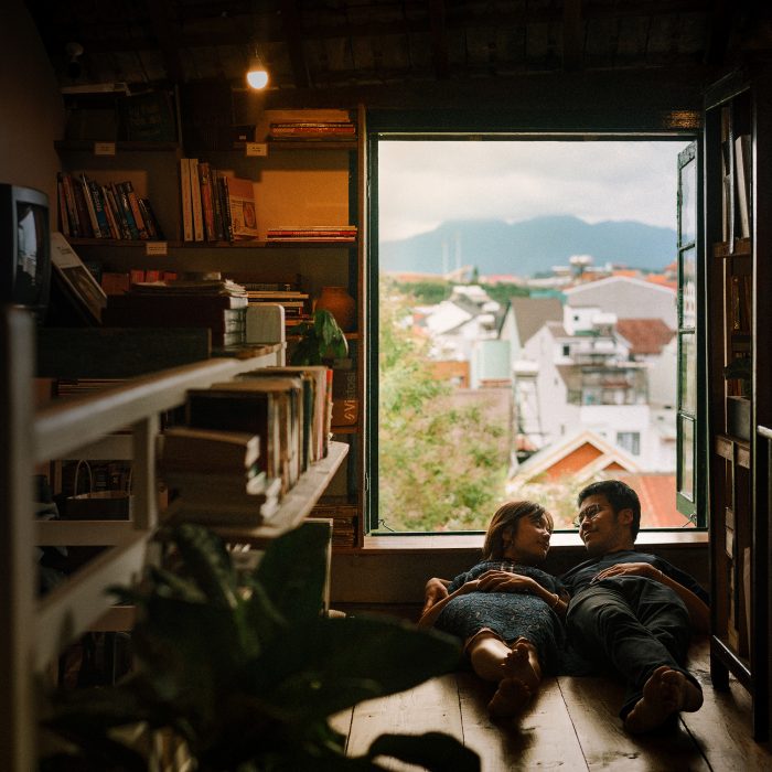 couple at home laying heads on window sill
