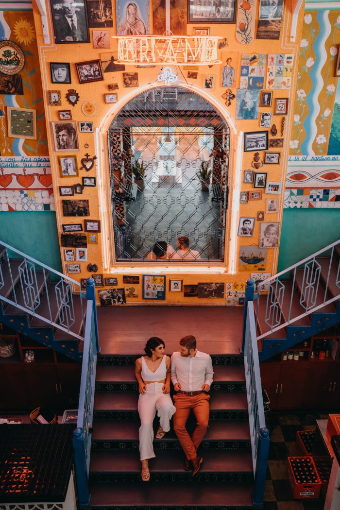 couple sitting on a staircase in colorful room
