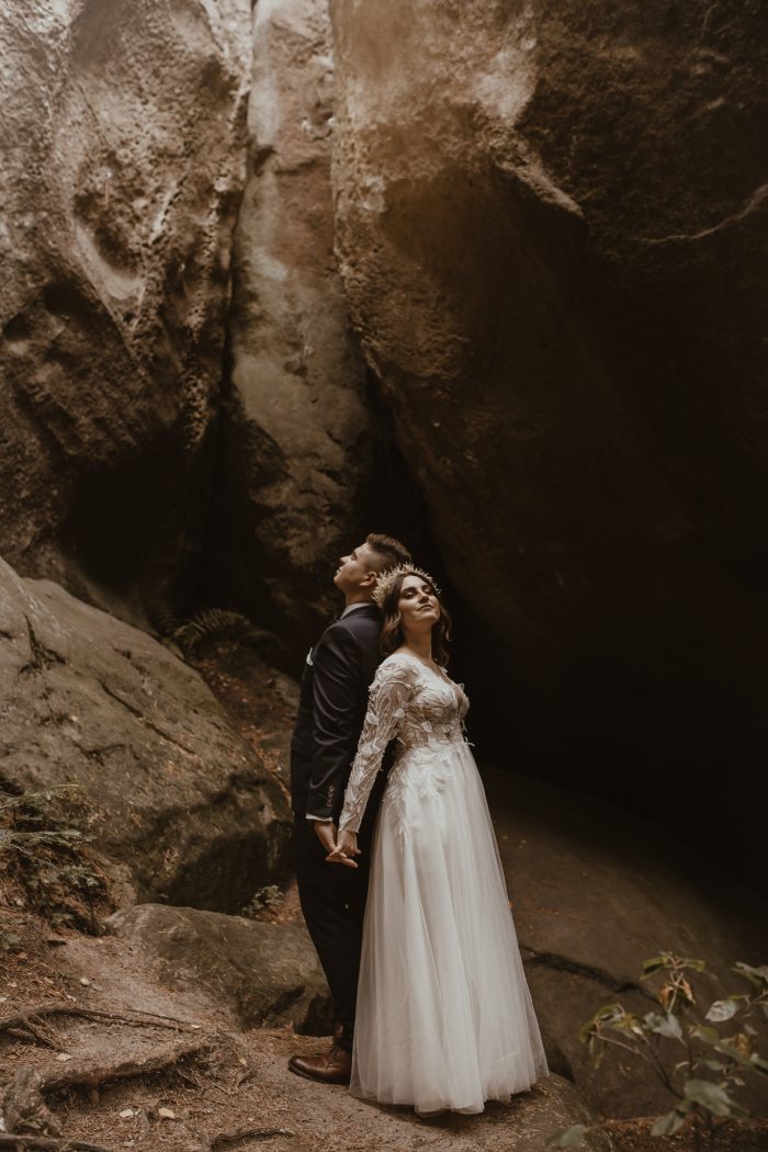 wedding day couple posing against rocks