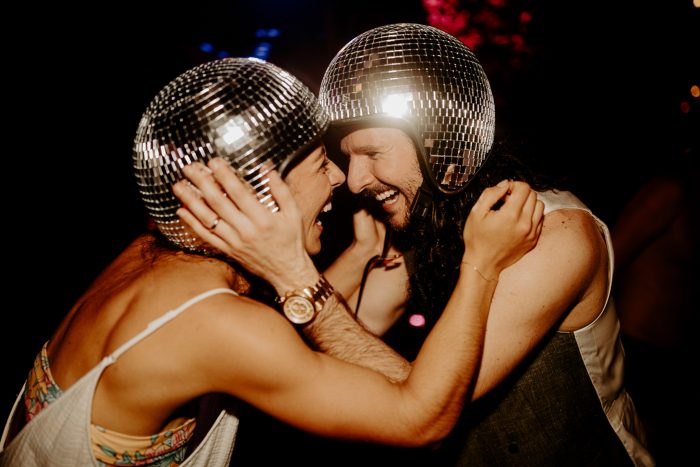 bride and groom wearing disco ball helmets