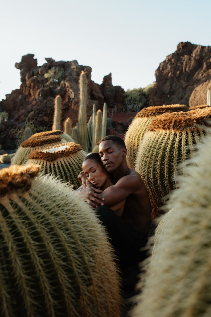 couple hugging in the desert amongst cacti