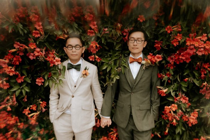 same-sex couple posing amongst red flowers