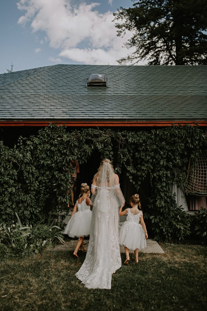 bride holding hands with flower girls