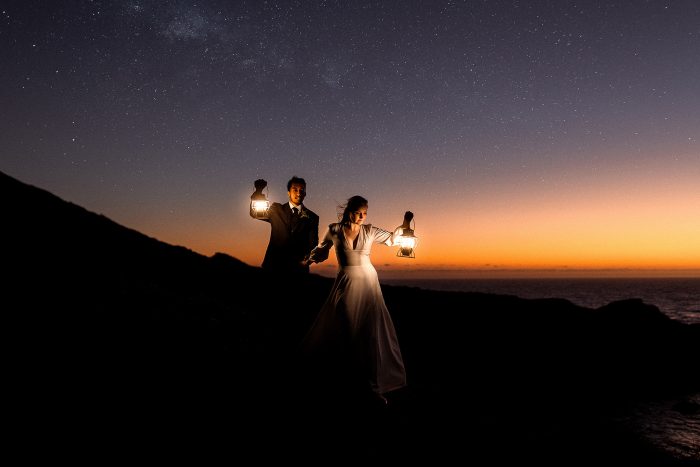 couple on mountain holding lanterns