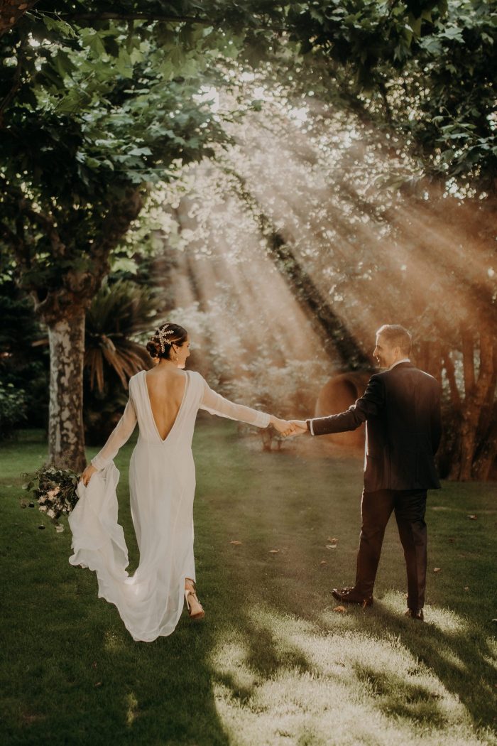 groom and bride walking through sun beams
