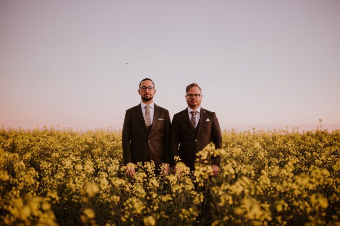 same-sex wedding couple in field of yellow flowers