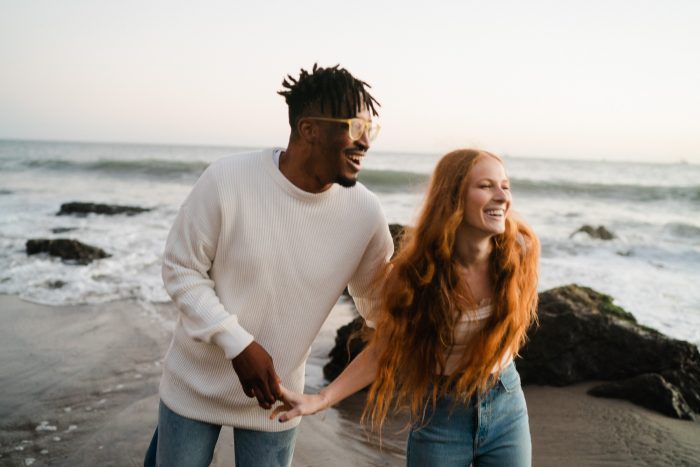 young couple laughing on the beach