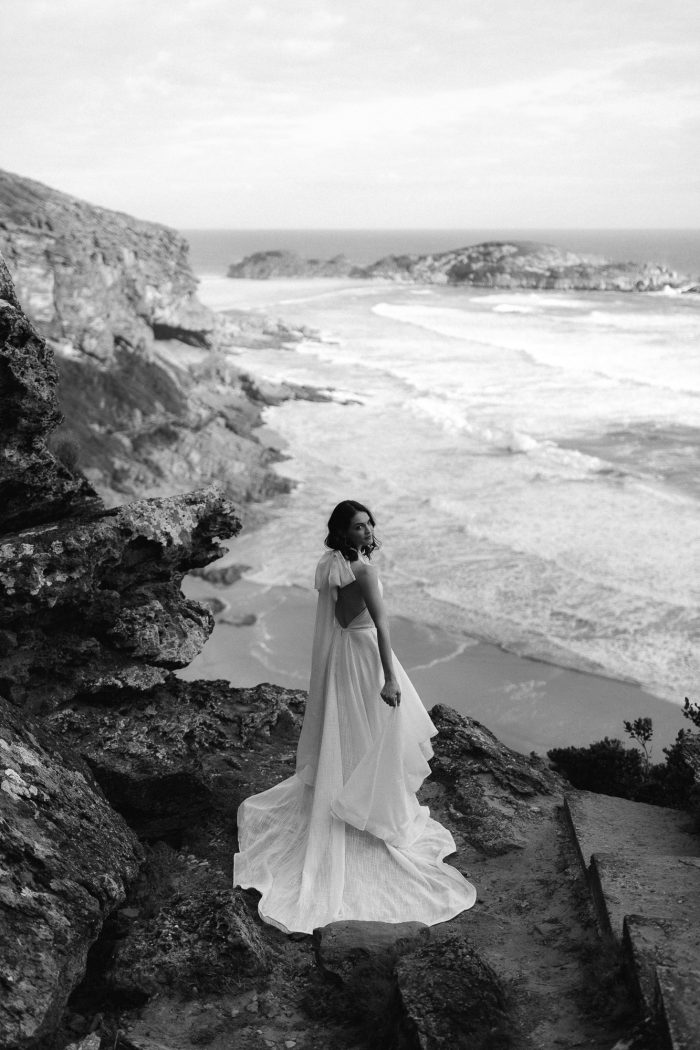 black and white wide shot of bride on beach