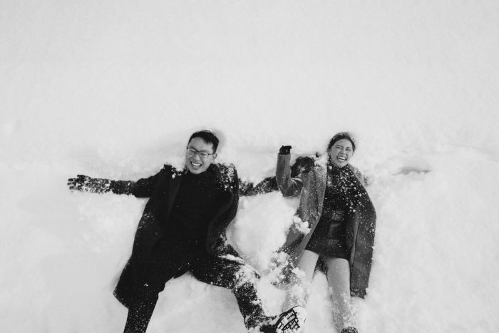 couple laughing and playing in snow