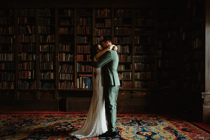wedding couple kissing inside a library room