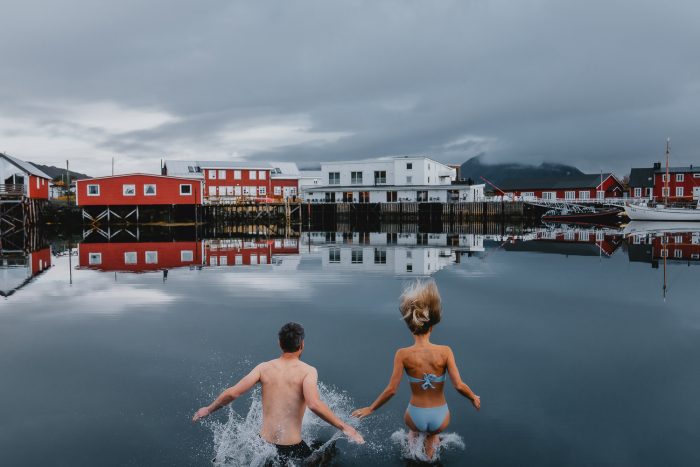 couple jumping into lake in Scandinavia 