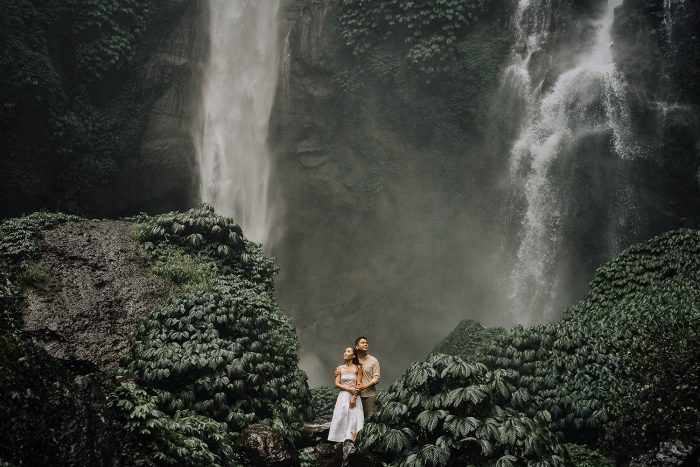 couple posant devant une cascade tropicale