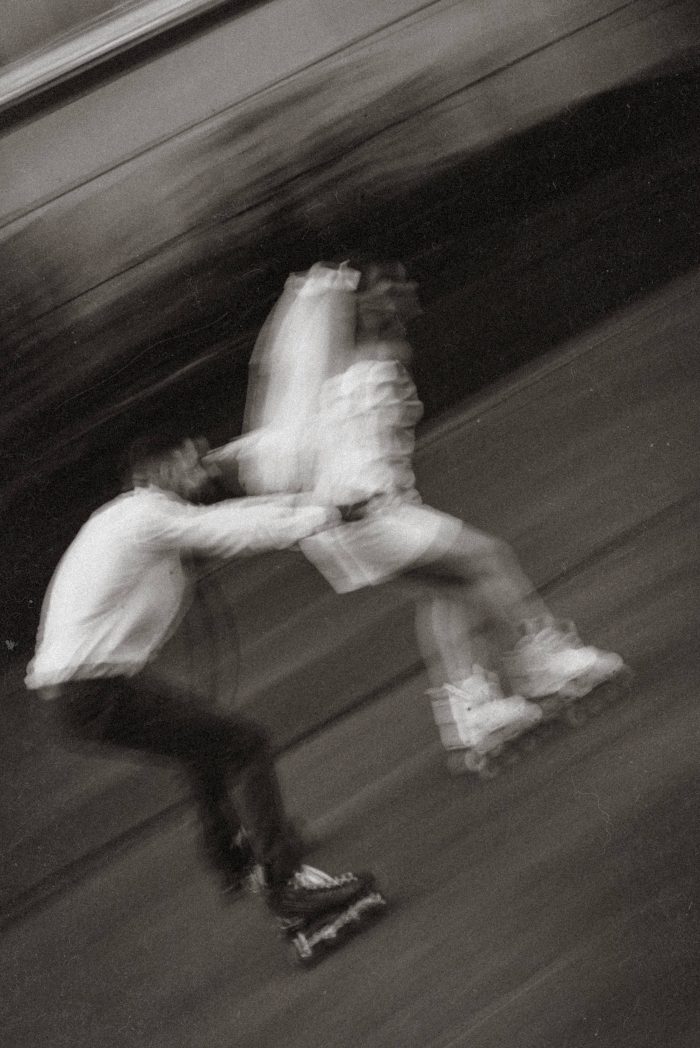 motion blur black and white photo couple rollerblading on wedding day