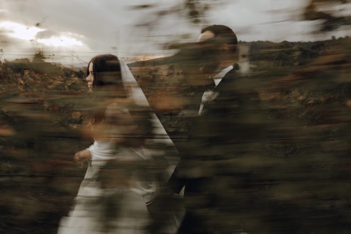 wedding day couple running through vineyard motion blur