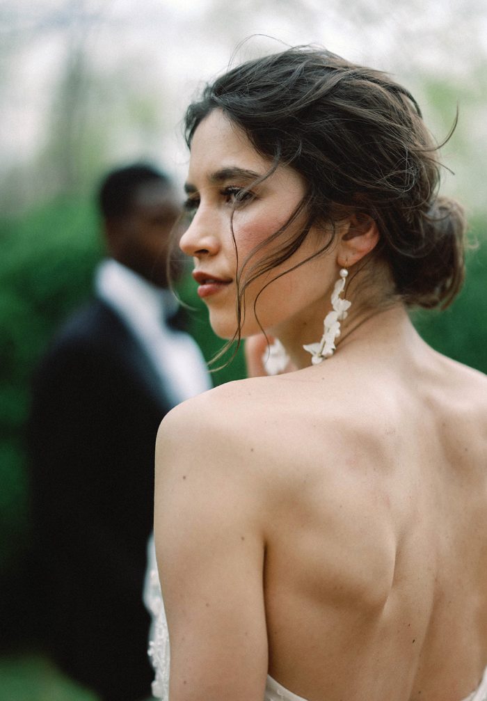 editorial bridal portrait with groom in the background
