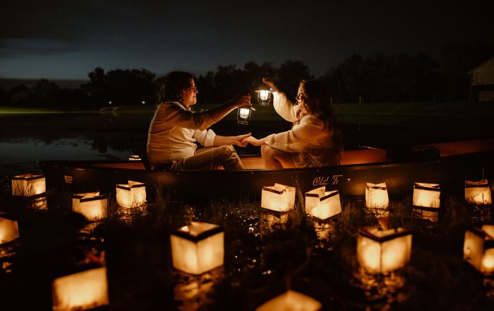 couple in canoe at nighttime with floating lanterns