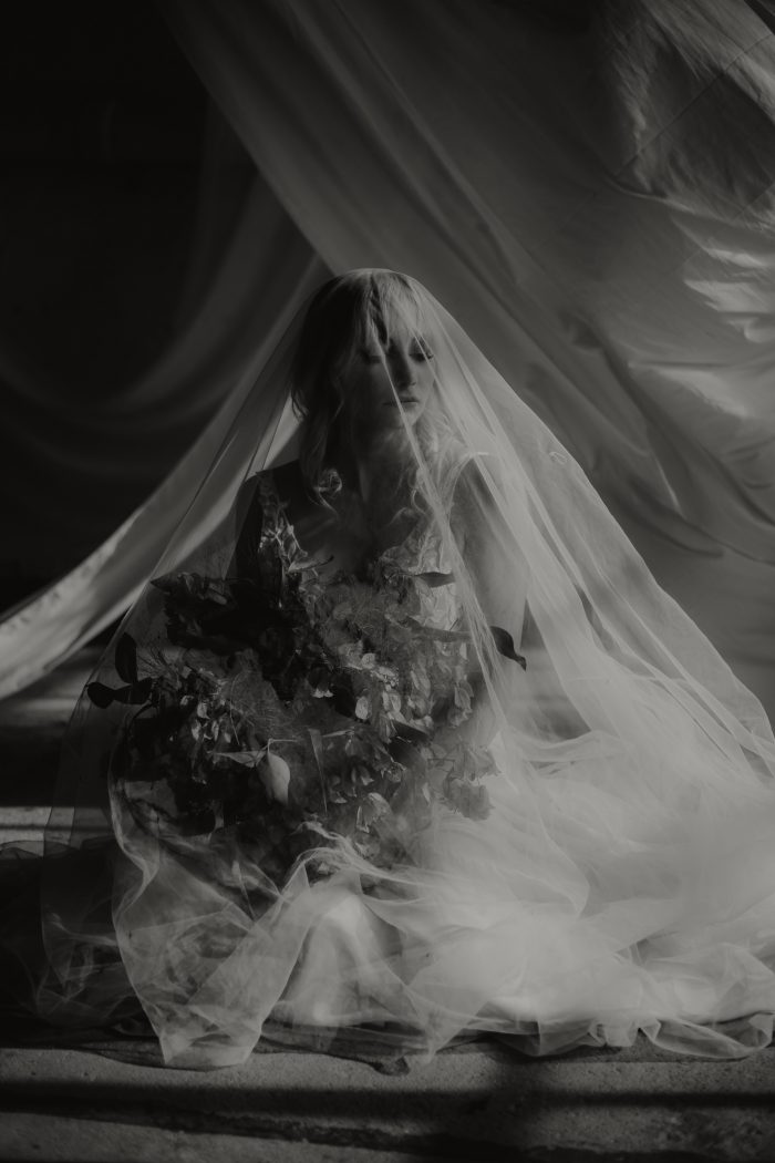 black and white moody portrait of a bride covered by veil